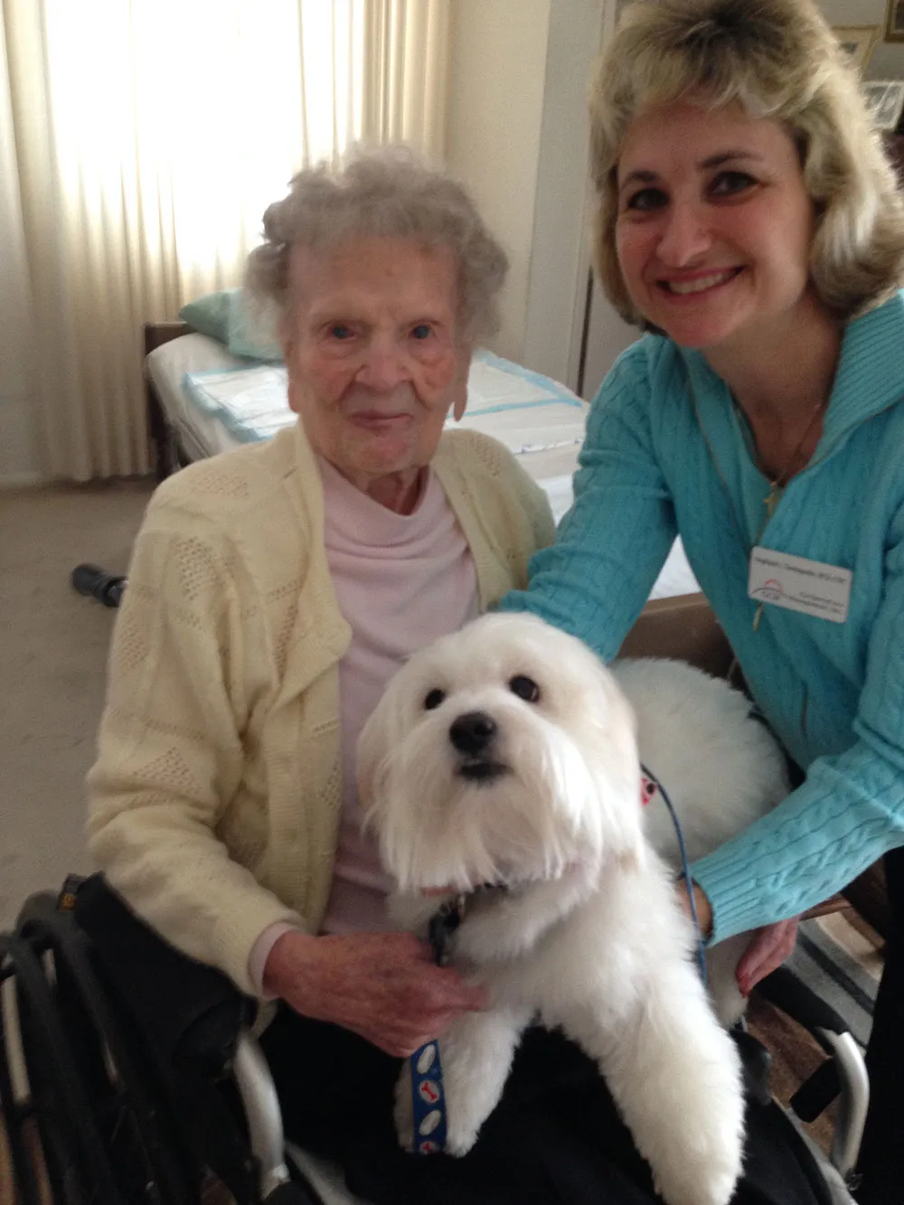 Elderly woman and caregiver with fluffy dog