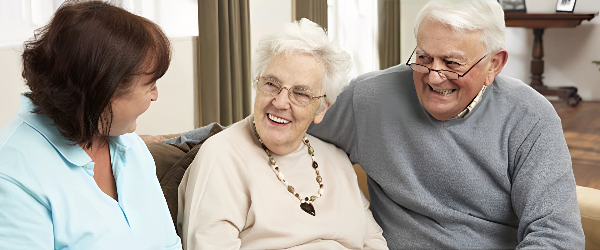 Elderly woman smiling warmly while sitting with family.