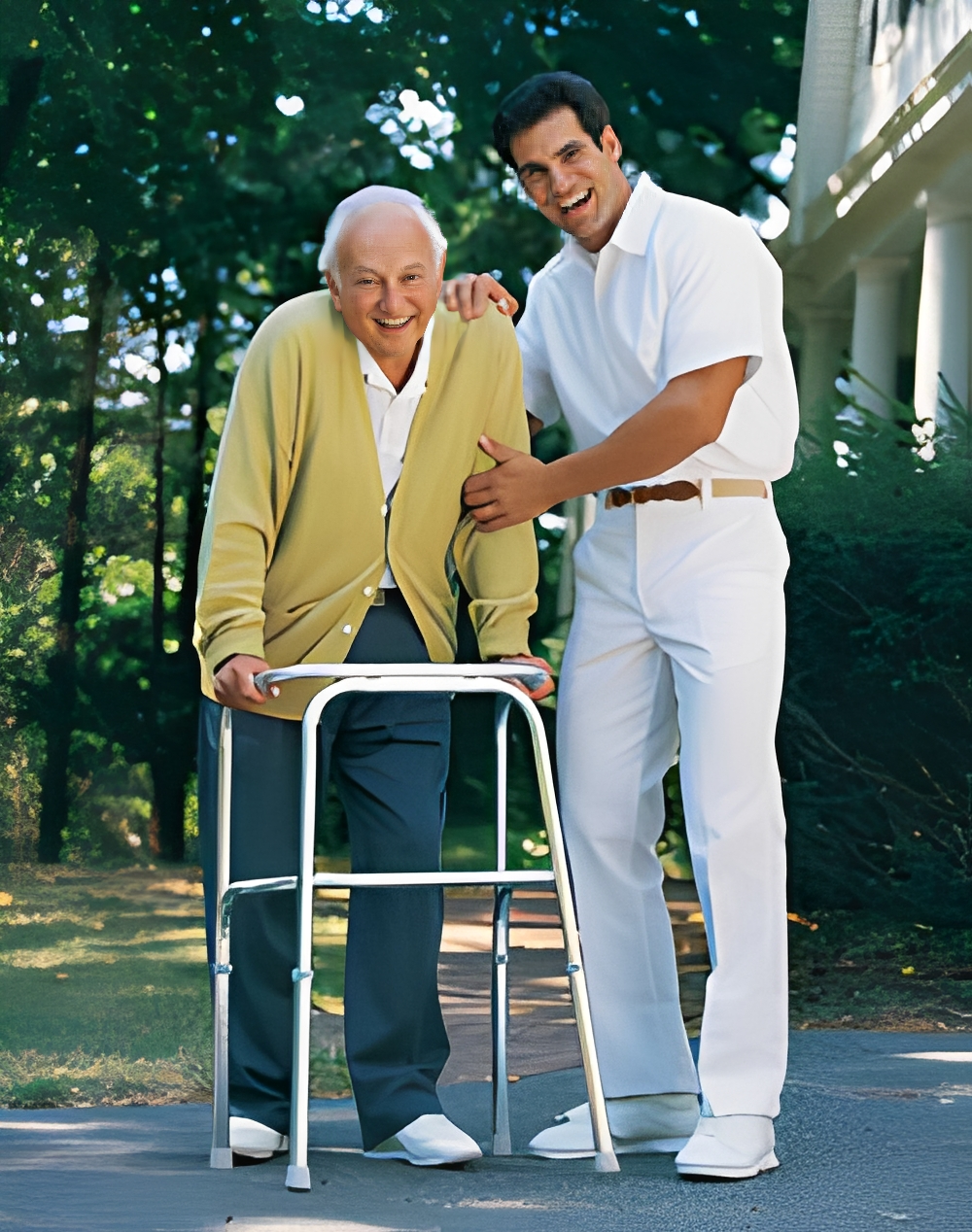 A young man assisting an elderly man with a walker outdoors.